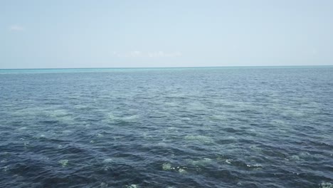 Drone-aerial-over-and-close-to-tropical-blue-water-in-the-great-barrier-reef-on-a-sunny-day