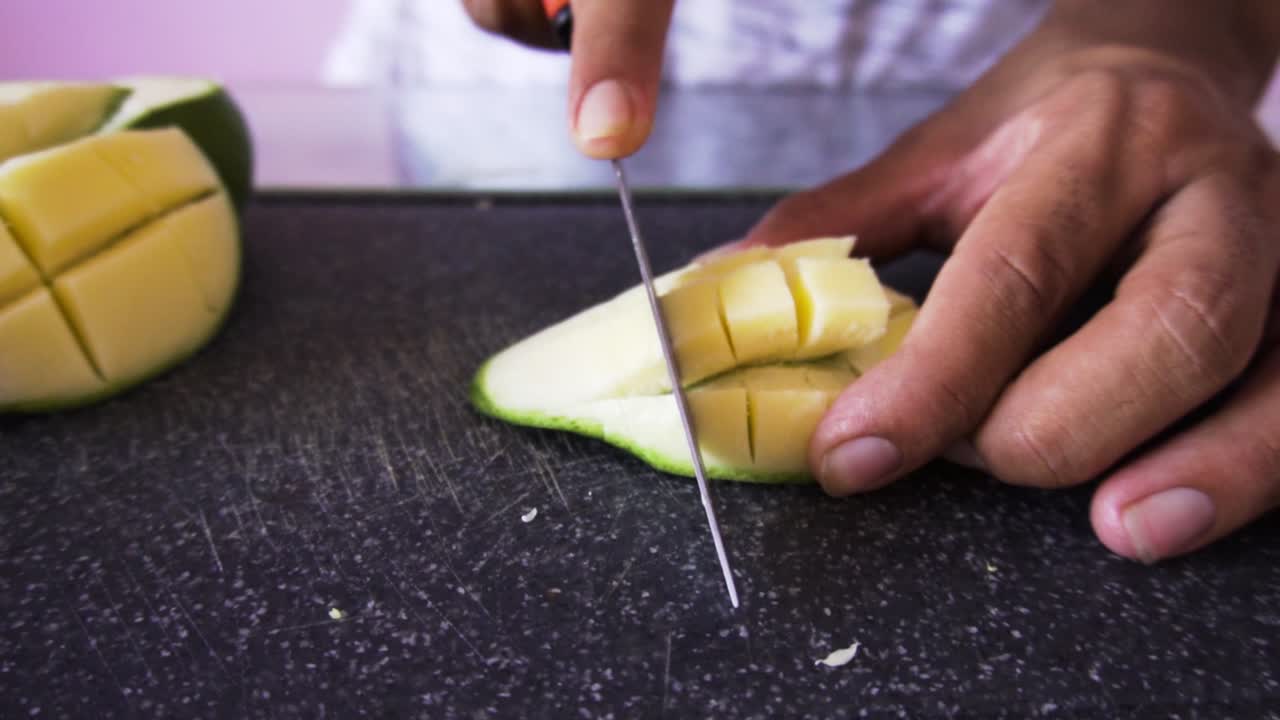 hombre cortando mangos para ensalada