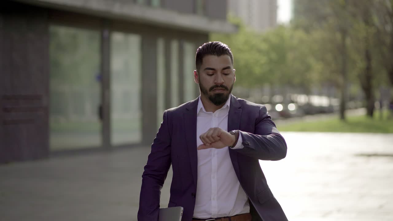 hombre de negocios serio con una computadora portátil corriendo por la calle