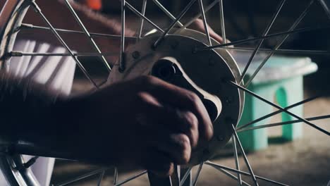 man fixing bicycle tire in a shop