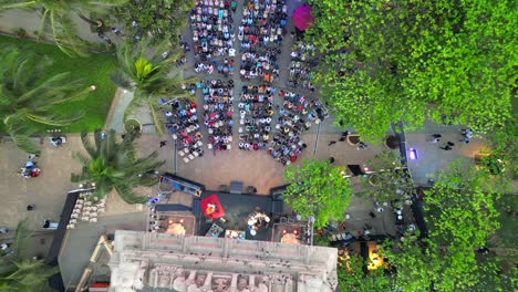 people-are-sitting-and-watching-the-program-at-Dadar-chow-patty-beach-bird-eye-closeup-to-wide-view-mumbai