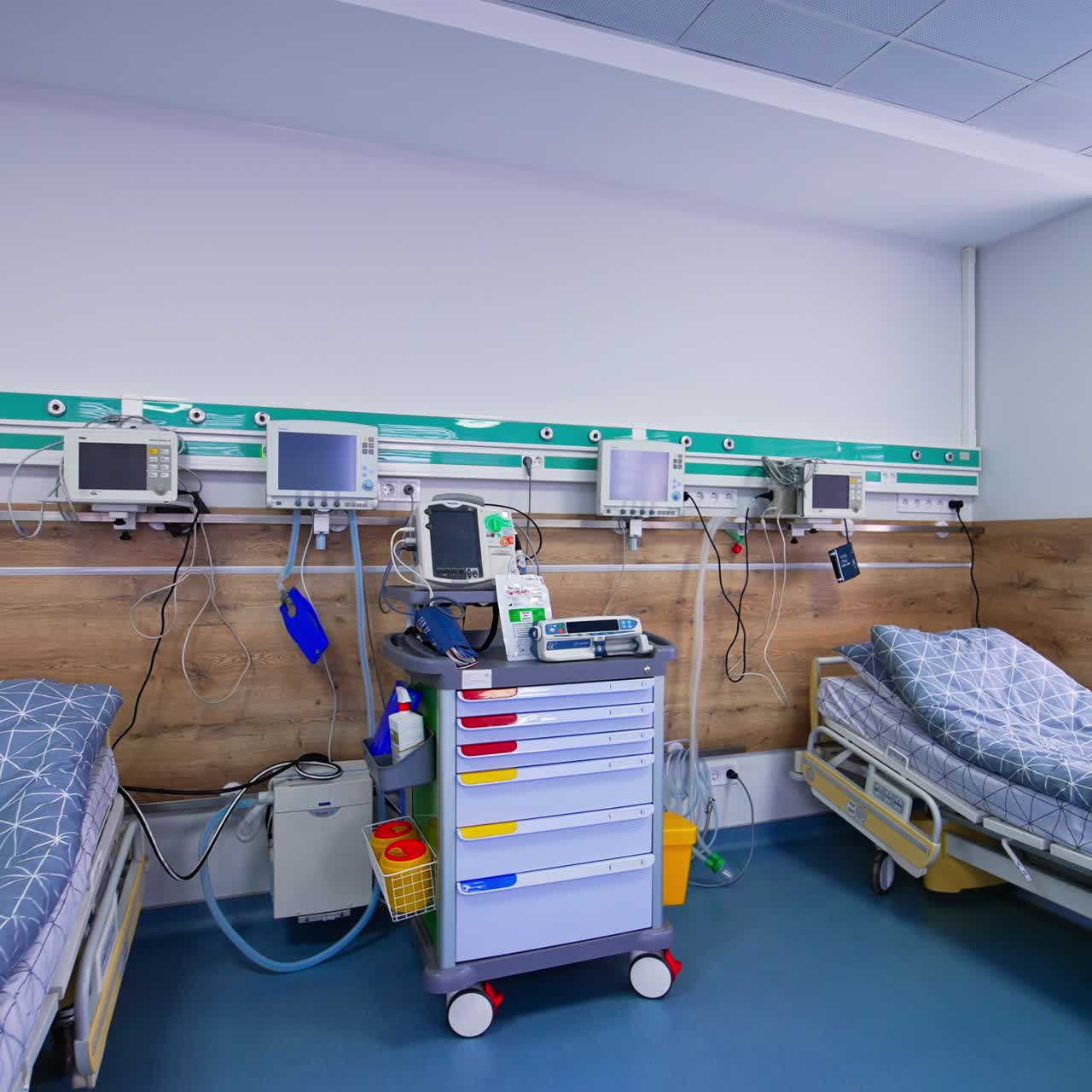 Hospital empty ward with three beds and new equipment with switched off monitors. Advanced equipment for resuscitation and saving lives