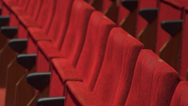 Close-up of red velvet theater seats in rows