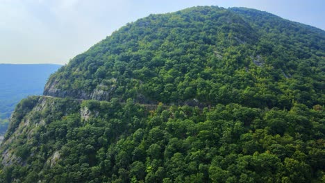 aerial drone video footage of an appalachian mountain river valley with a beautiful domed mountain with a road