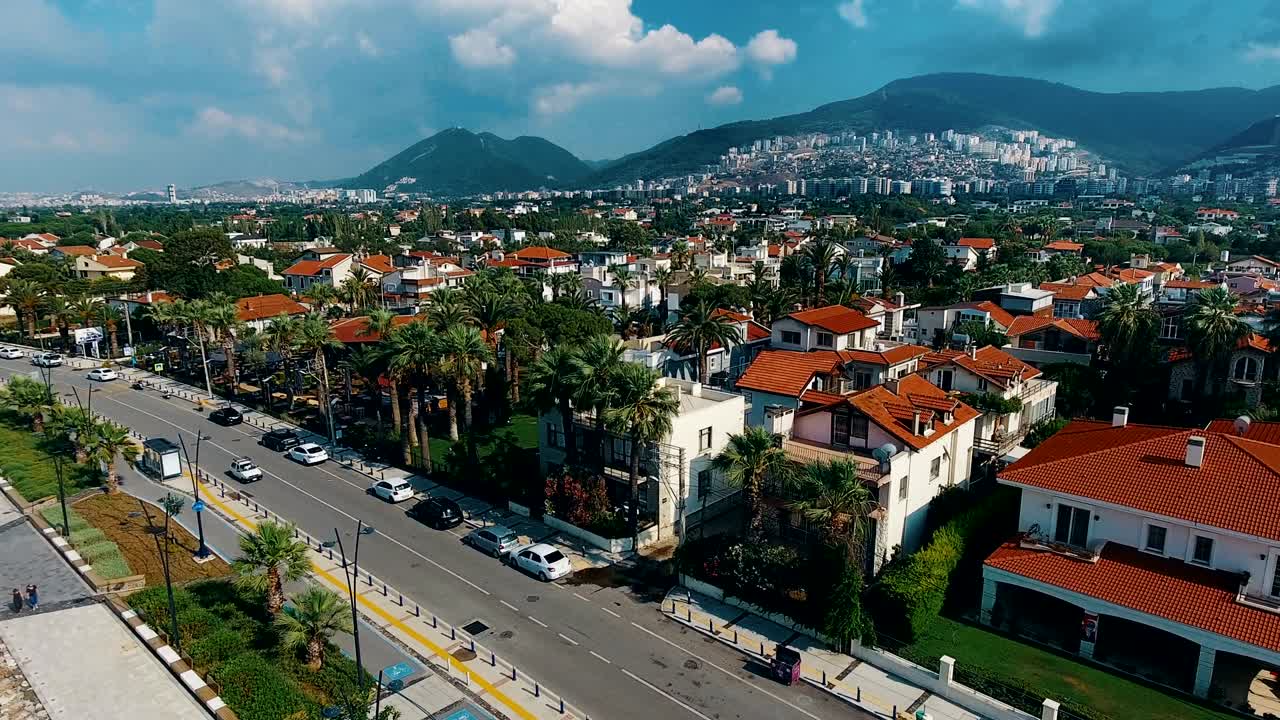 drone volando sobre la línea costera 4k. vista aérea de las olas del mar, calles y edificios de la ciudad.