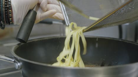 a professional chef in italy is prepairing a plate of pasta and scampi in his kitchen - 04