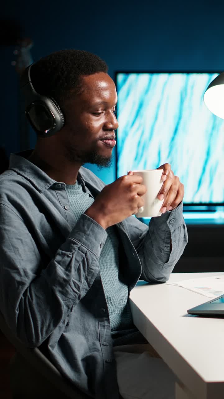 Man with headphones drinking from a mug