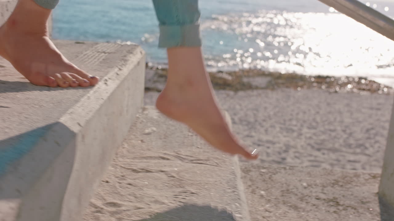 vicino piedi donna che cammina a piedi nudi giù per i gradini sulla spiaggia godendo di una calda giornata di sole ragazza spensierata che esplora lo stile di vita delle vacanze estive