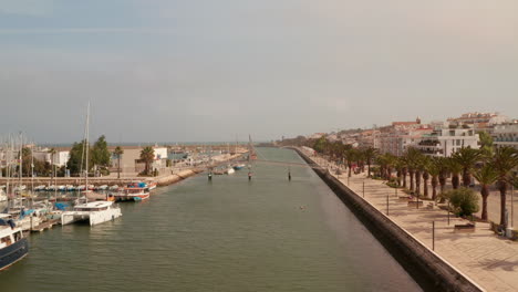 Puerto-De-Lagos,-Drone-Volando-Hacia-Adelante-Sobre-El-Canal-Principal,-Portugal,-Vista-Aérea-Sobre-El-Paseo-Marítimo,-Día-Soleado