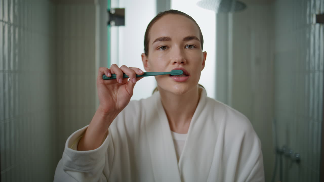 Closeup girl toothbrushing morning at home. Pretty woman getting ready to work