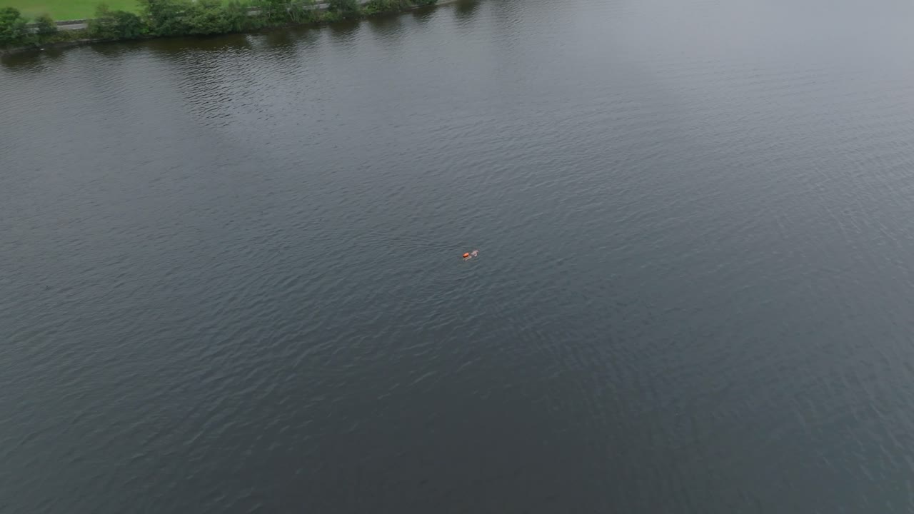loch lomond의 잔잔한 바다에서 수영하는 한 명의 수영 선수의 아크 드론 샷