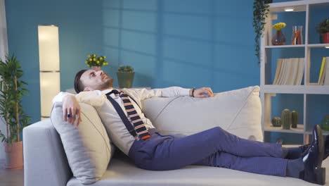 thoughtful and tired cool stylish young man lying on sofa.