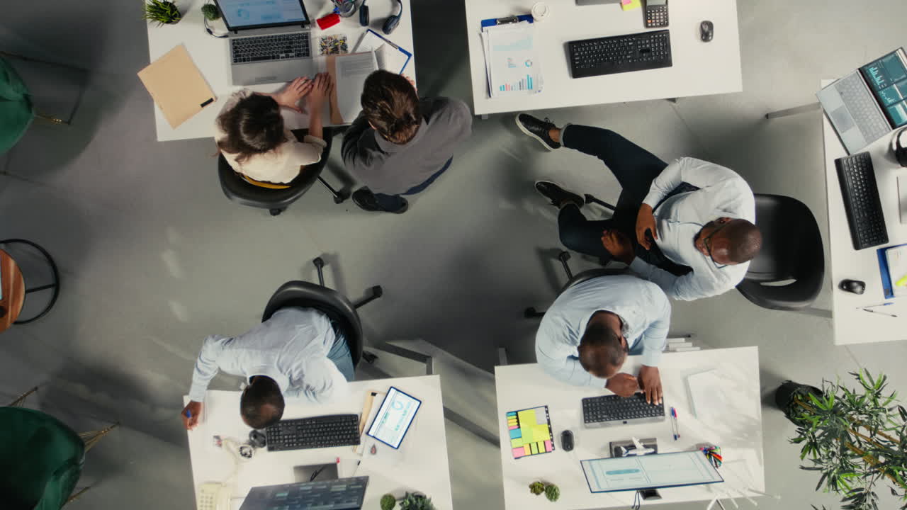 Top down view zoom in of employees consulting on new corporate project