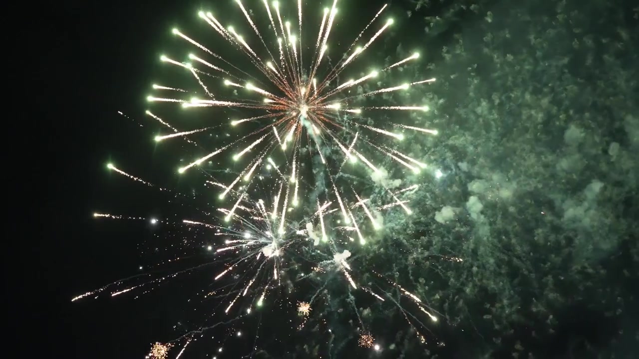 Potente finale di fuochi d'artificio che riempie il cielo notturno con lampi luminosi, particelle scintillanti e fumo alla deriva. Eccellente per celebrazioni di Capodanno, festival, concerti e grandi finali di eventi