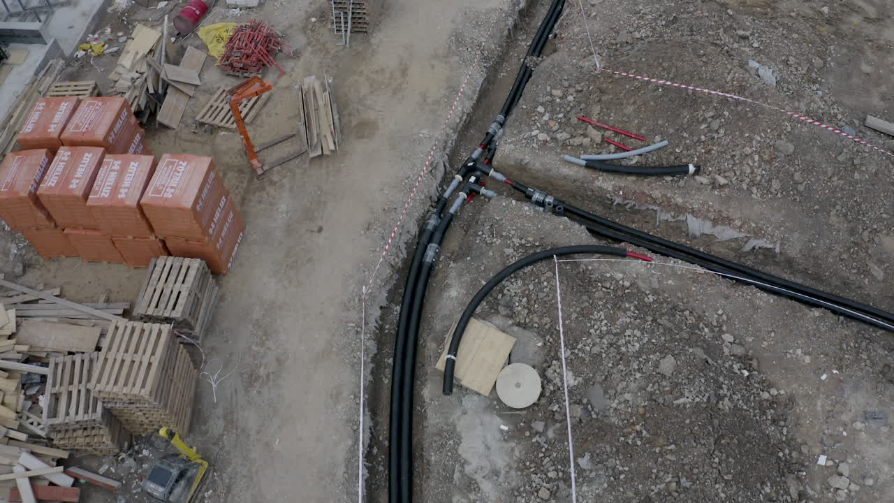 cables y tuberías tendidos en una zanja abierta en un sitio de construcción