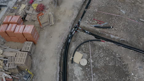 cables and pipes laid down in an open ditch at a construction site