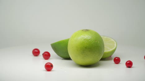 Freshly-Sliced-Green-Limes-With-Red-Currants-For-Juicing---Close-Up-Shot