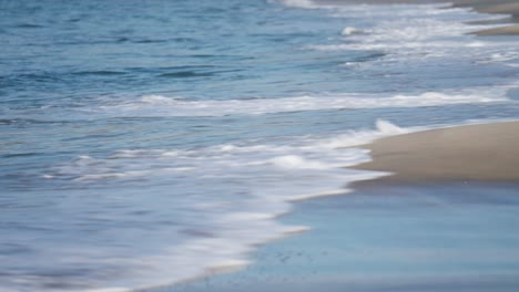 low waves gently roll on the sandy beach