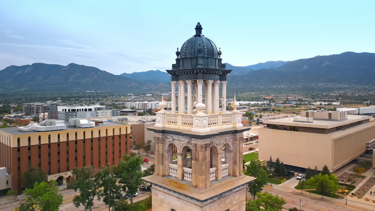Beautiful cupola and columns of the clock tower in Colorado Springs City Hall. Scenery of American city with mountain range at backdrop