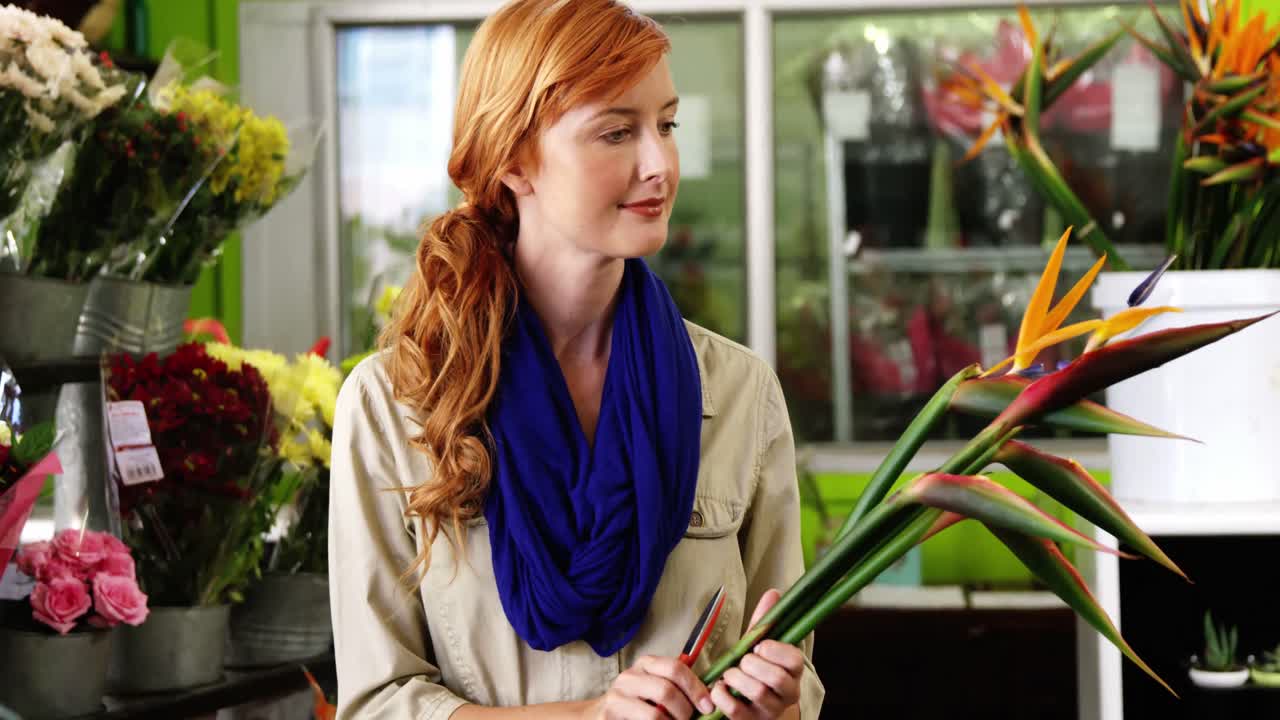 Kvindelig blomsterhandler holder blomster