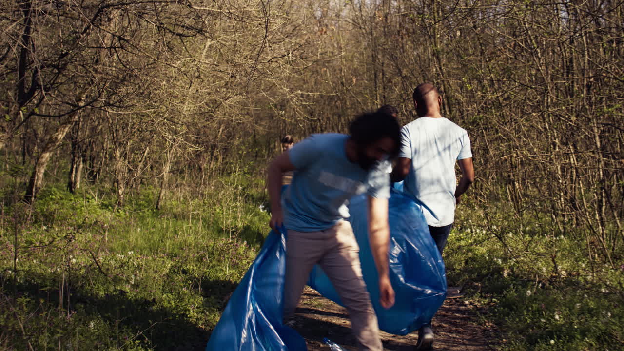 Diverse activists cleaning up rubbish in a garbage disposal bag