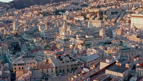 Sunset-drone-flight-over-port-city-of-Genoa,-view-of-ancient-buildings-and-striking-historic-architecture,-Liguaria,-Italy