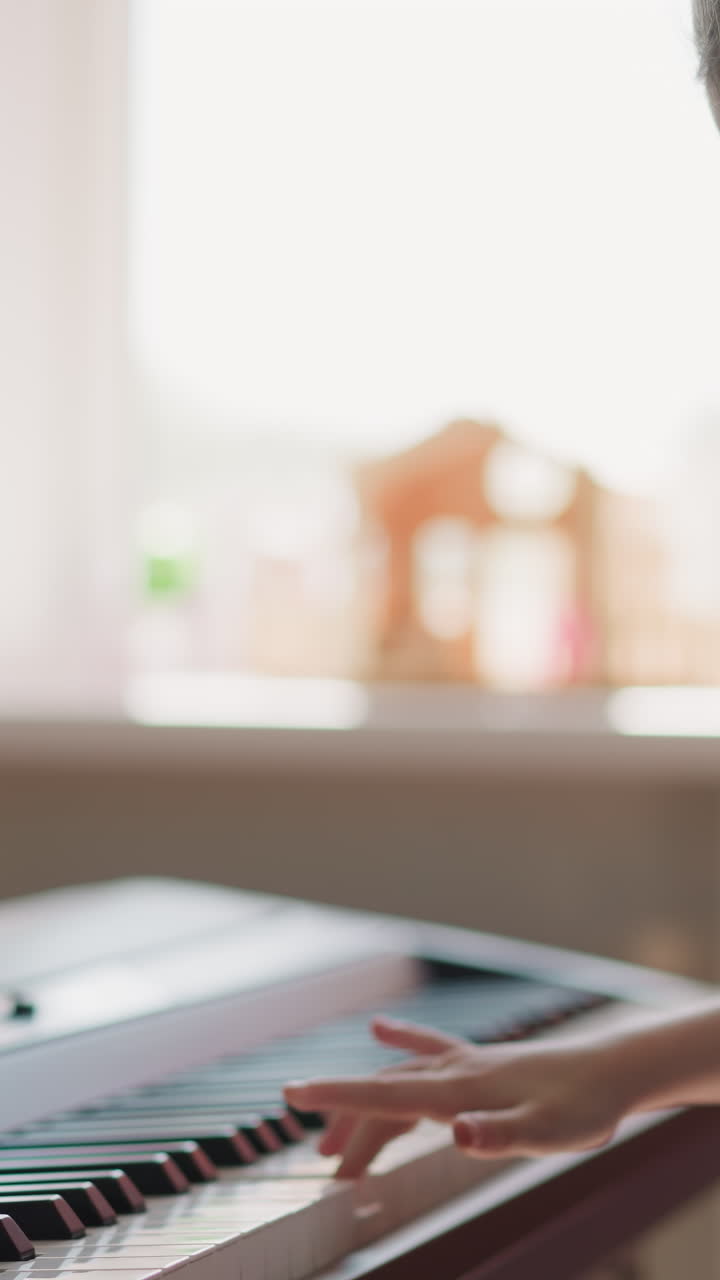 Cute schoolgirl plays synthesizer standing in cozy room at home. Girl engages in hobby undergoing rehabilitation after back injury side view on blurred background