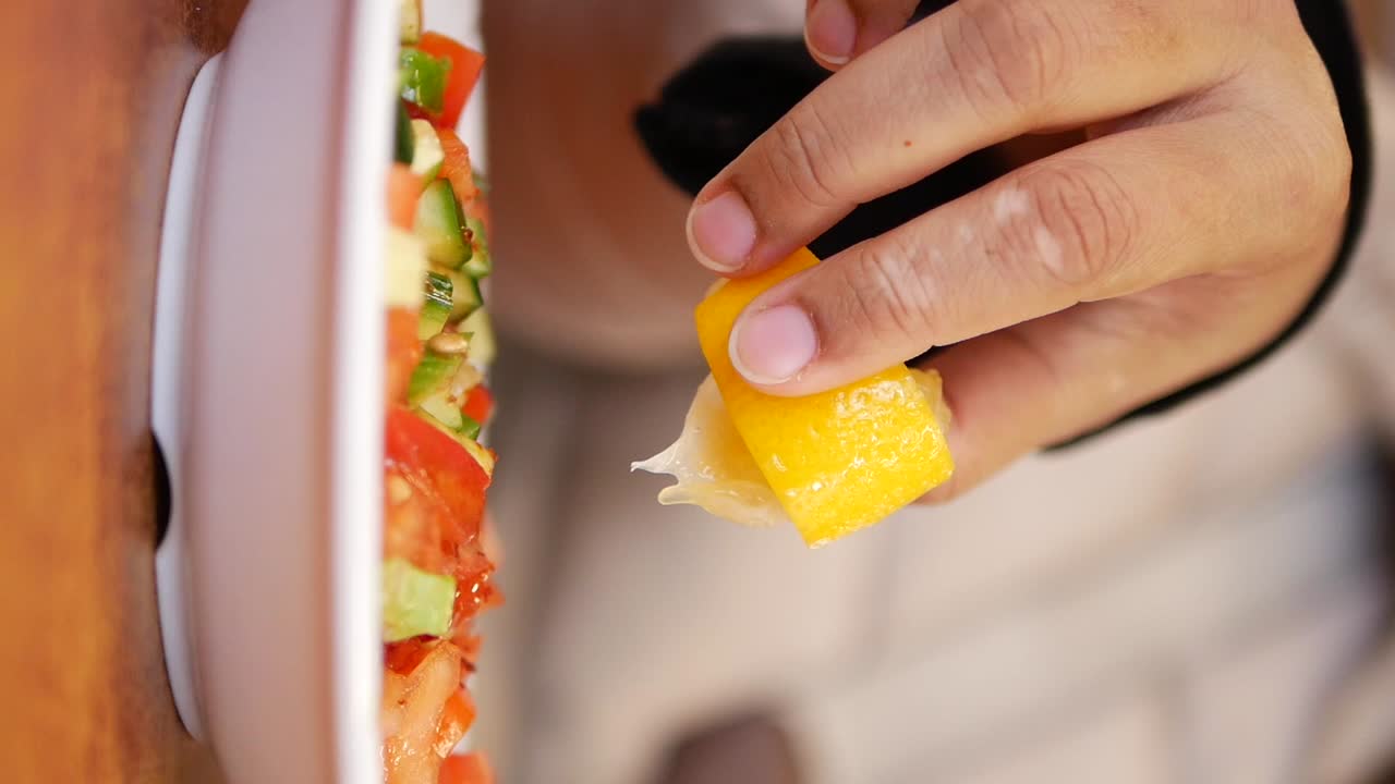 Person eating salad with lemon