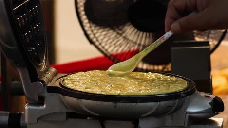 반죽을 고, 요리하고, 와플 아이언을 닫습니다.