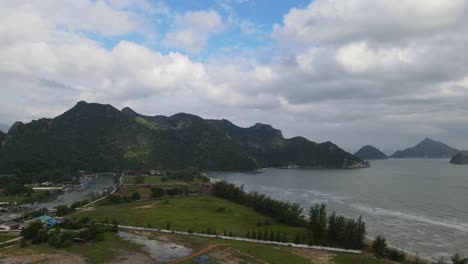 aerial footage sliding to the right revealing a fishing village and the beach front at an estuary in khao sam roi yot national park, prachuap khiri khan, thailand