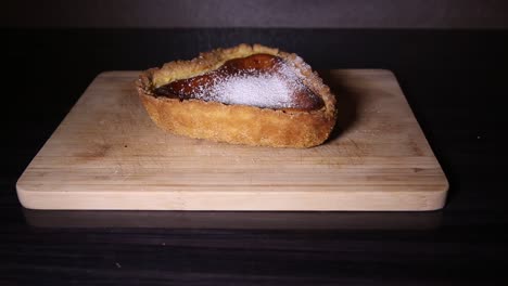 pouring sugar on heart shaped cheesecake close up shoot