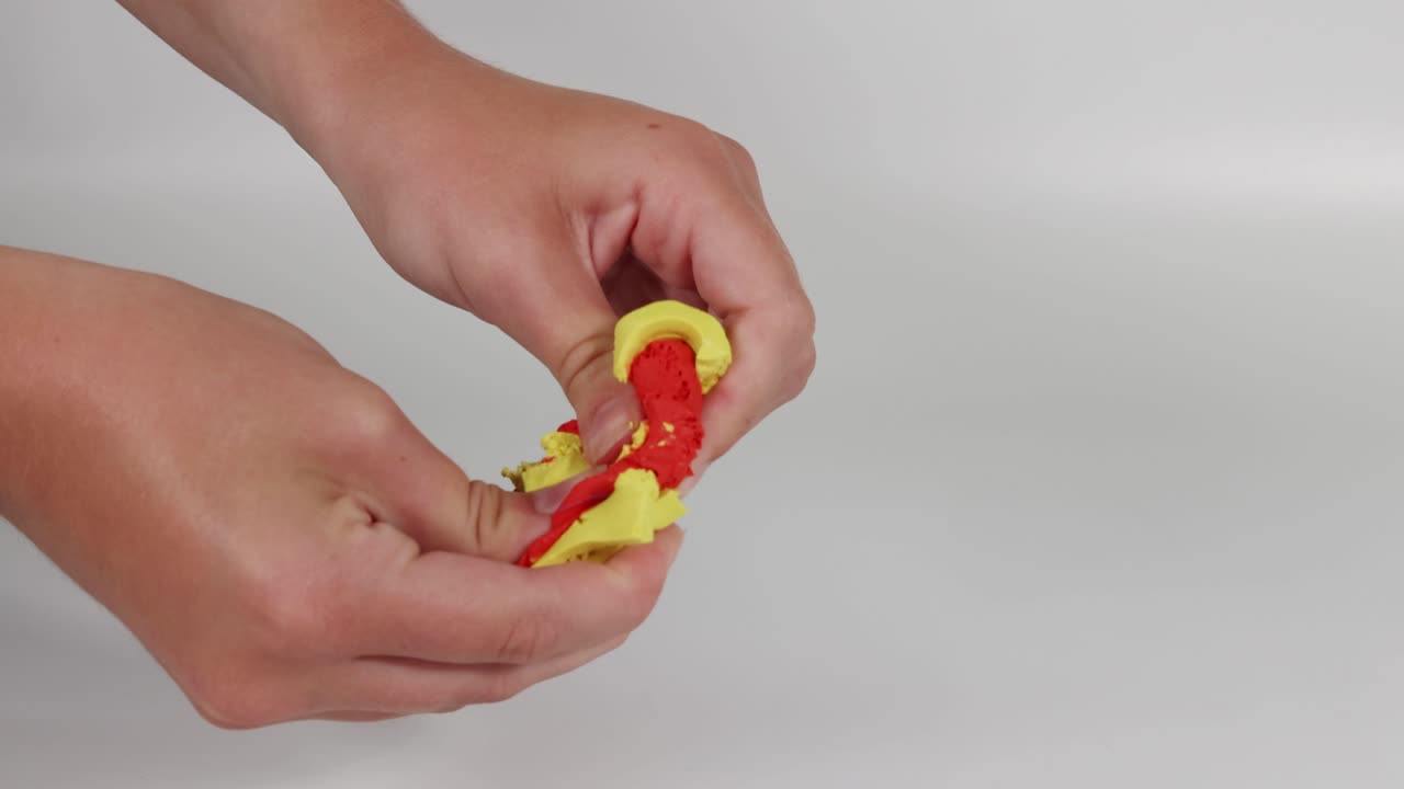 manos moldeando y mezclando arcilla de colores