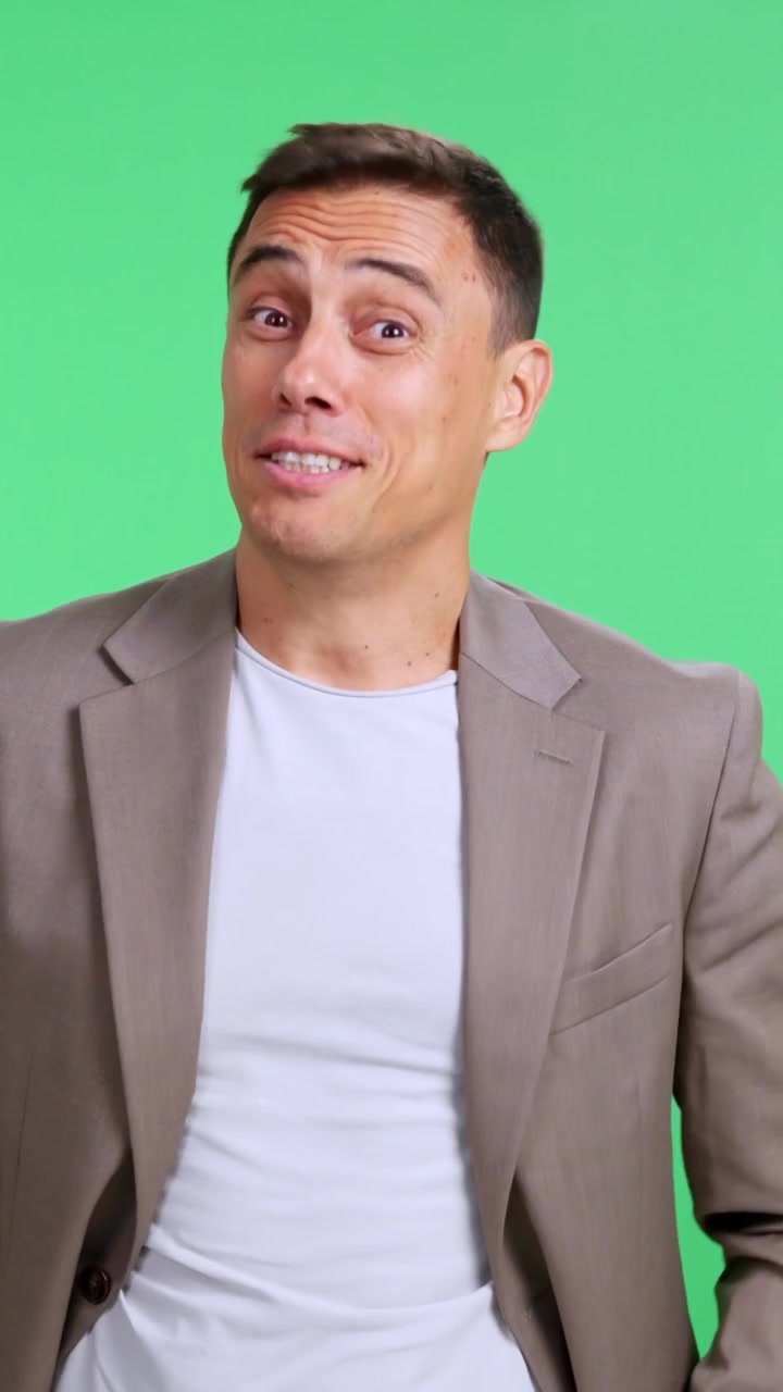 Confident man winking and pointing with his thumb and fingers to the side