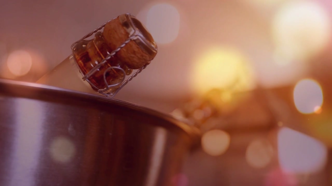 Camera pushing in bar, champagne cork bouncing on bowl rim, bulbs creating bokeh for design