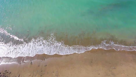 Turquoise-ocean-waves-breaking-on-a-empty-tropical-sandy-beach