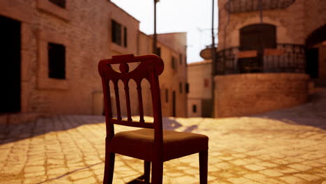 una vieja silla de madera se sienta sola en una calle de adoquines en una pequeña ciudad medieval