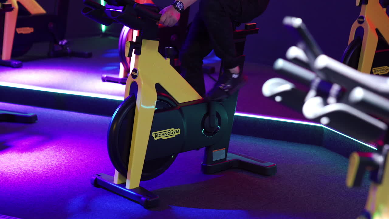 Man riding exercise bike in gym. Man spin legs on smart trainer at gym
