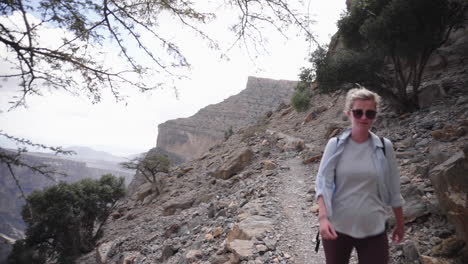 woman hiking through the wadi mountains of oman