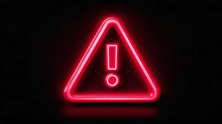 Un cartello luminoso al neon con un triangolo e un punto esclamativo, che simboleggia cautela e attenzione in un’insegna visiva distintiva