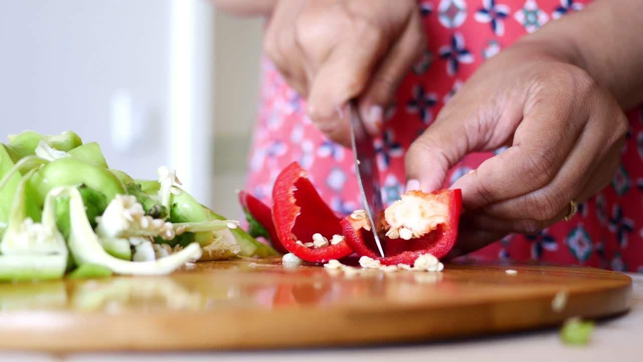 mujer cortando pimienta roja y pimienta verde