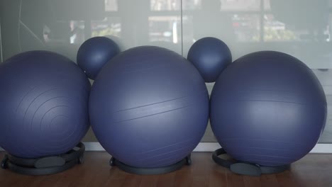 three blue exercise balls in a gym