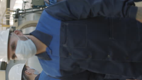 supervisor putting sanitizer on hands of plant workers