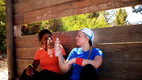 Amigos-Bebiendo-Agua-Después-Del-Entrenamiento-Durante-La-Carrera-De-Obstáculos.