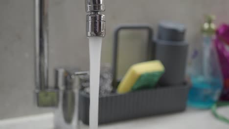 agua corriendo del grifo en la cocina