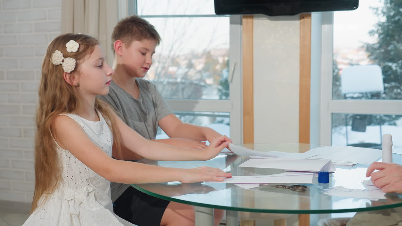 Kids and mother creating paper craft at table. Mother applying glue to her paper while children focus on their work, cozy indoor setting with crafting materials like glue and scissors