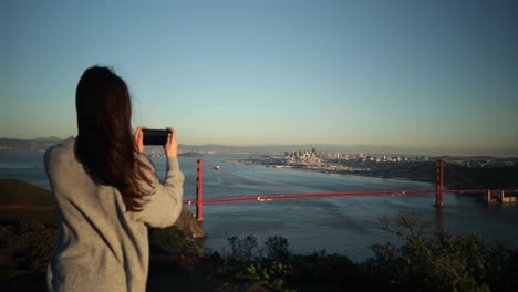 woman photographing the golden gate bridge, san francisco