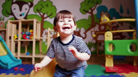joyful toddler playing and laughing in a playroom