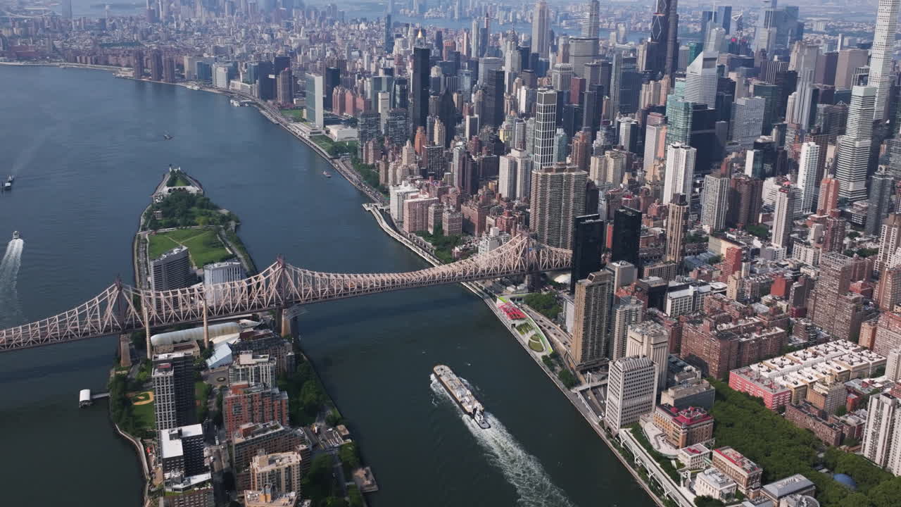 Drone che segue un battello fluviale sull'East River presso l'isola di Roosevelt a New York City.