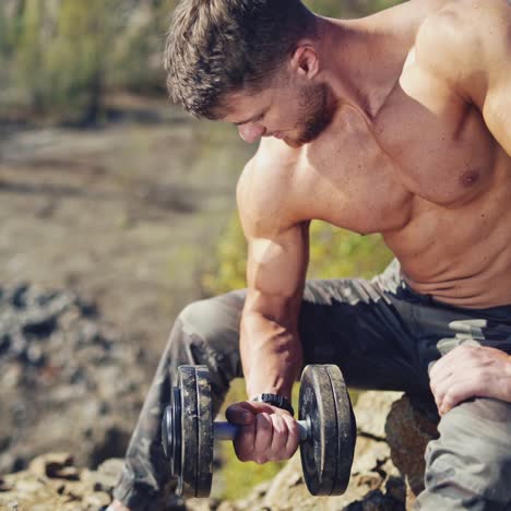. concentrated young sportsman. portrait of young man holding dumbbell