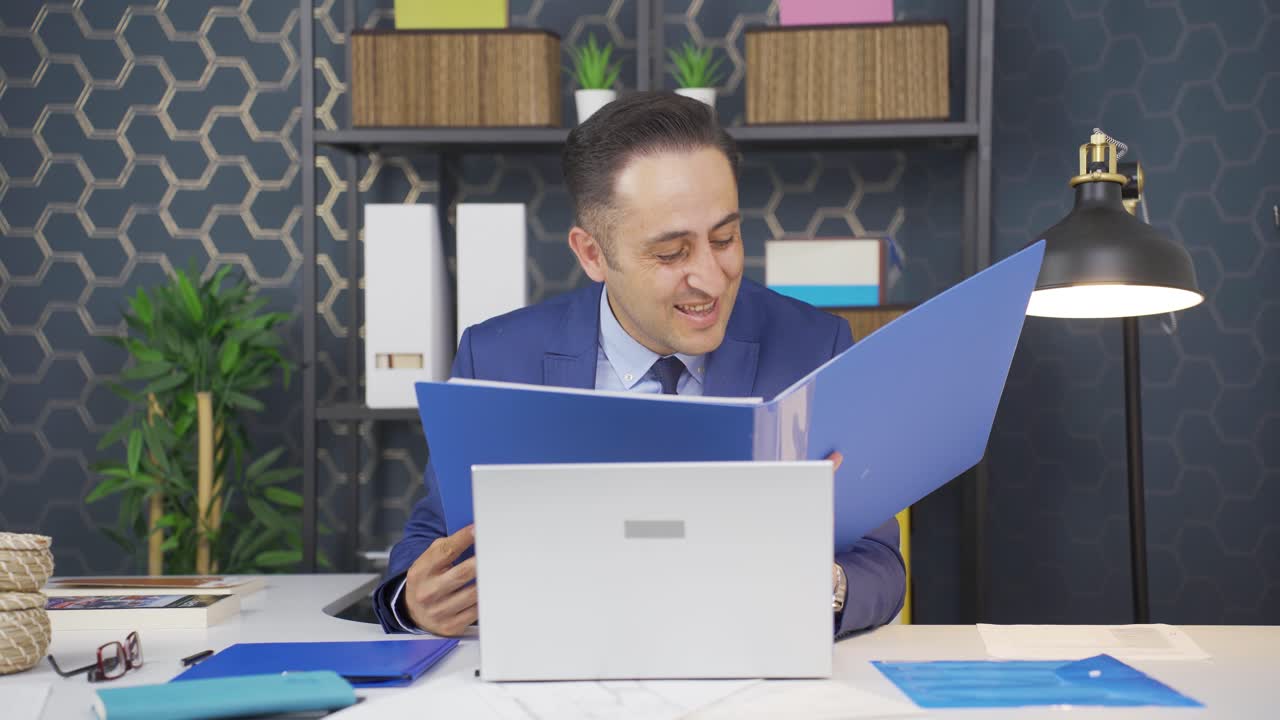 hombre de negocios exitoso trabajando felizmente en archivos de papeleo.